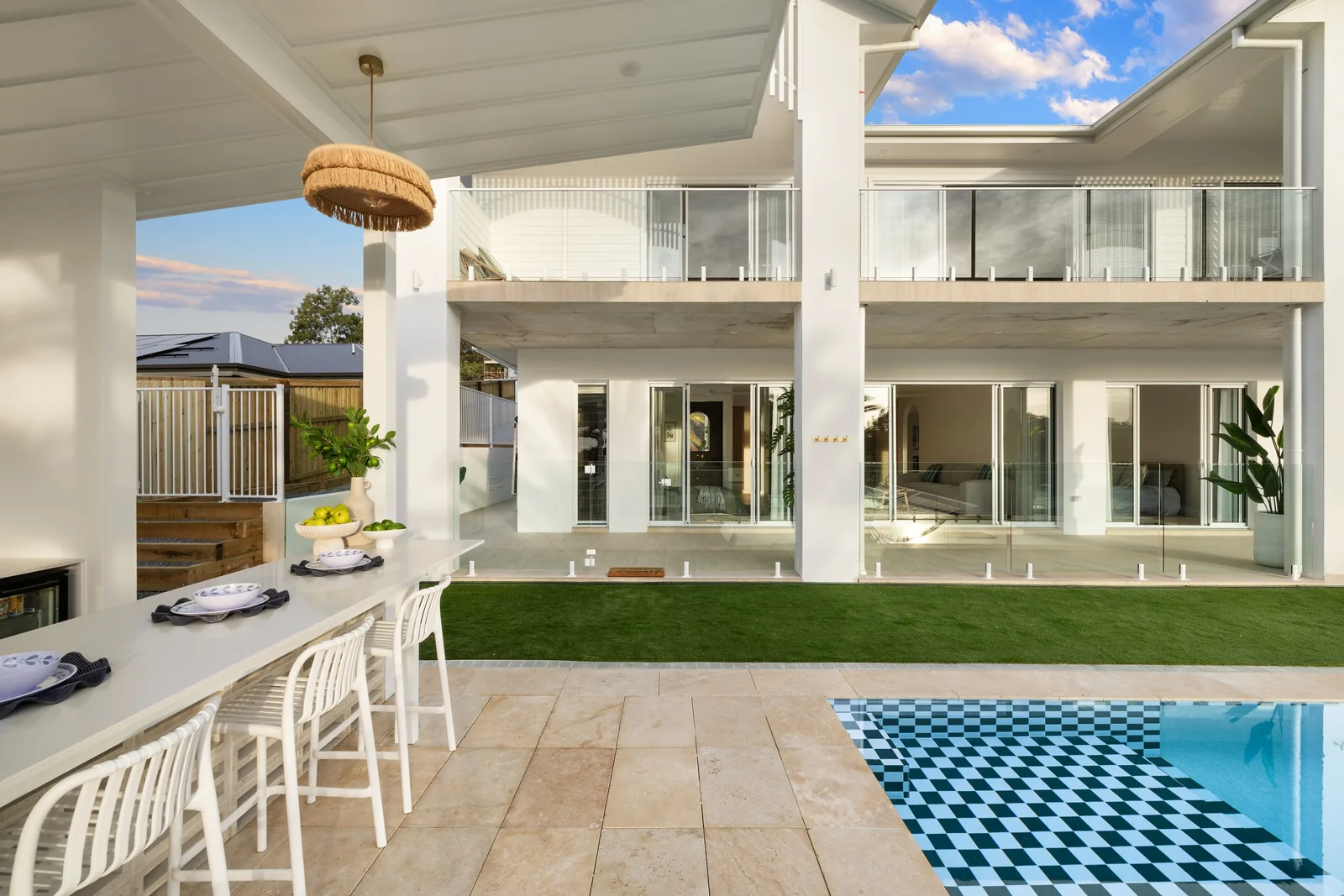 Covered alfresco seating beside the pool, looking towards the house