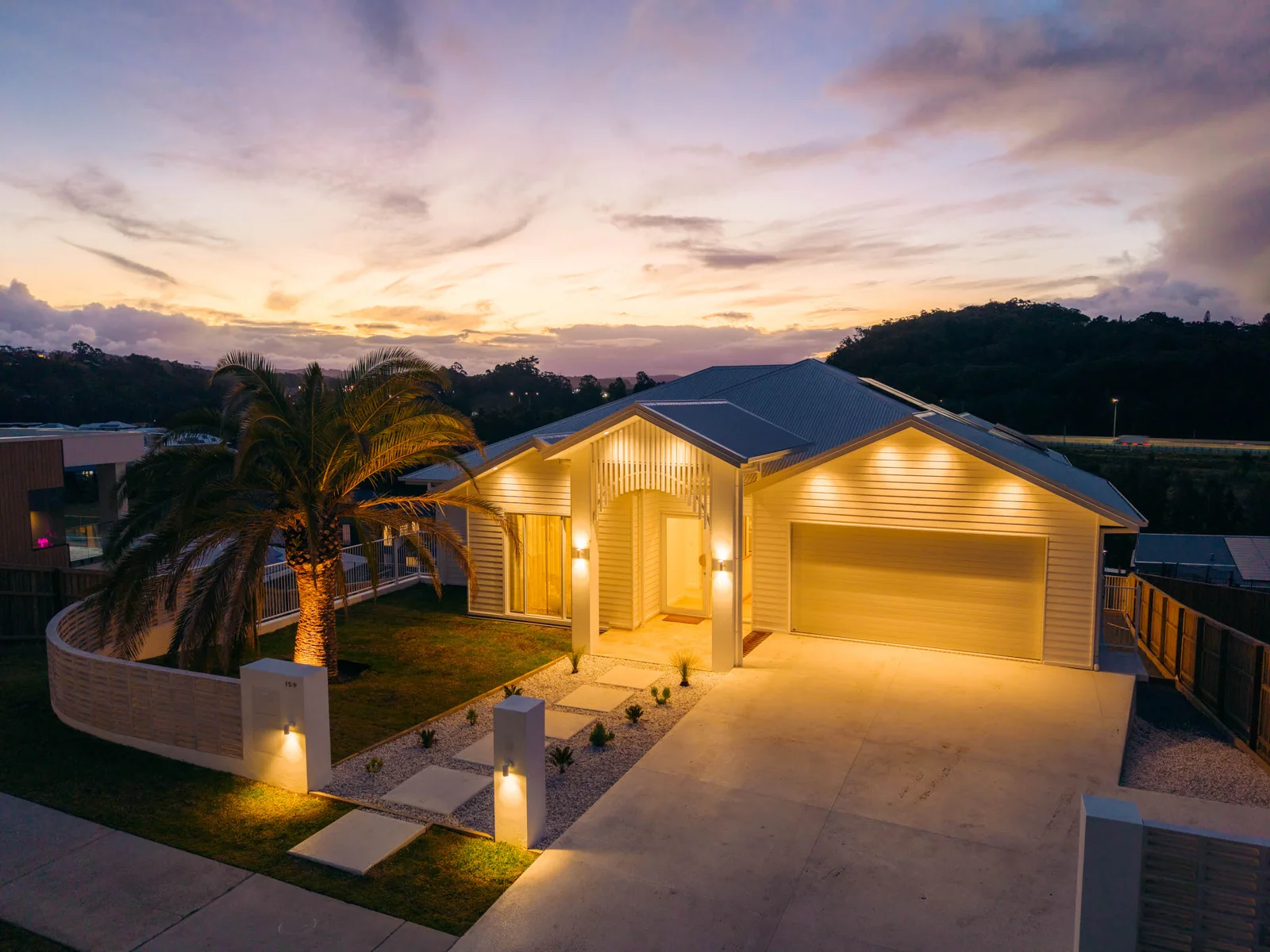 The front of Palmilla with its date palm against a sunset sky